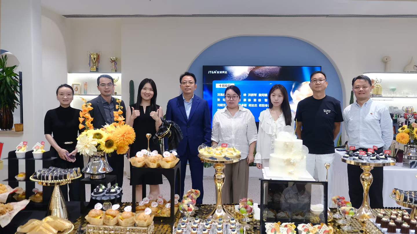 Kelly Zhang and JT&N colleagues standing behind a dessert table at the firm's October birthday celebration