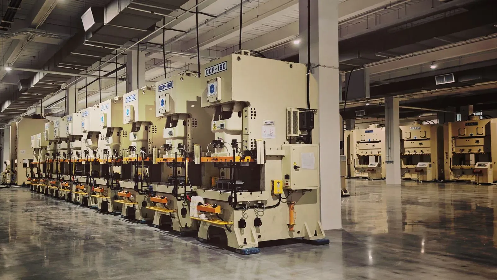 A row of metal stamping presses in a factory hall